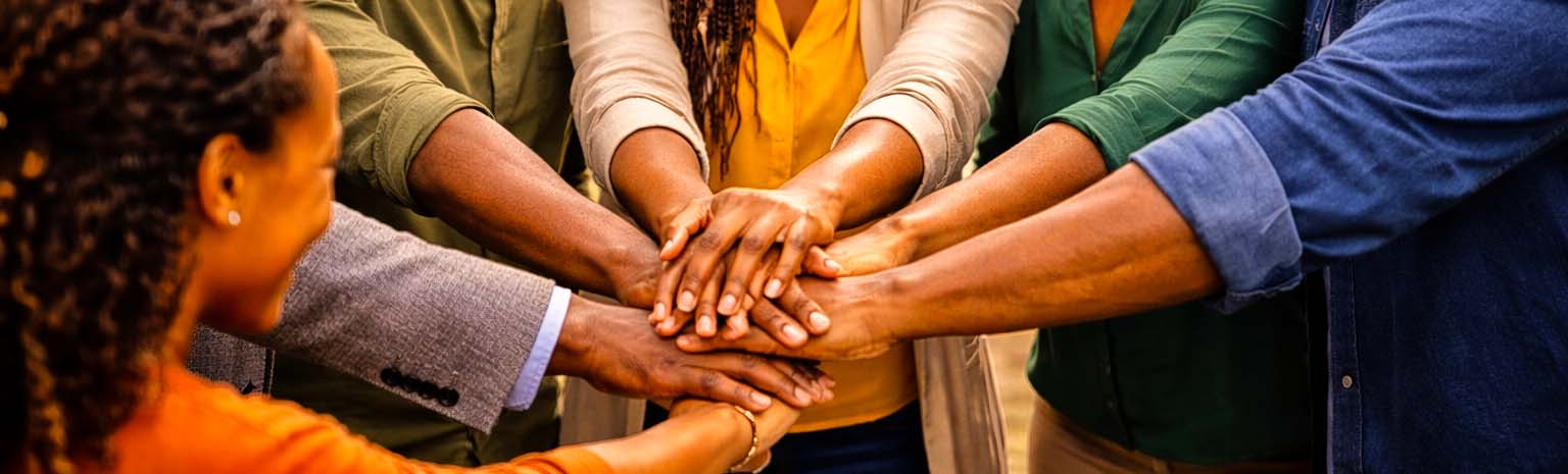 Community members putting hands together in unity representing Kenyatta Matibabu SACCO Benevolent Fund support in Nairobi