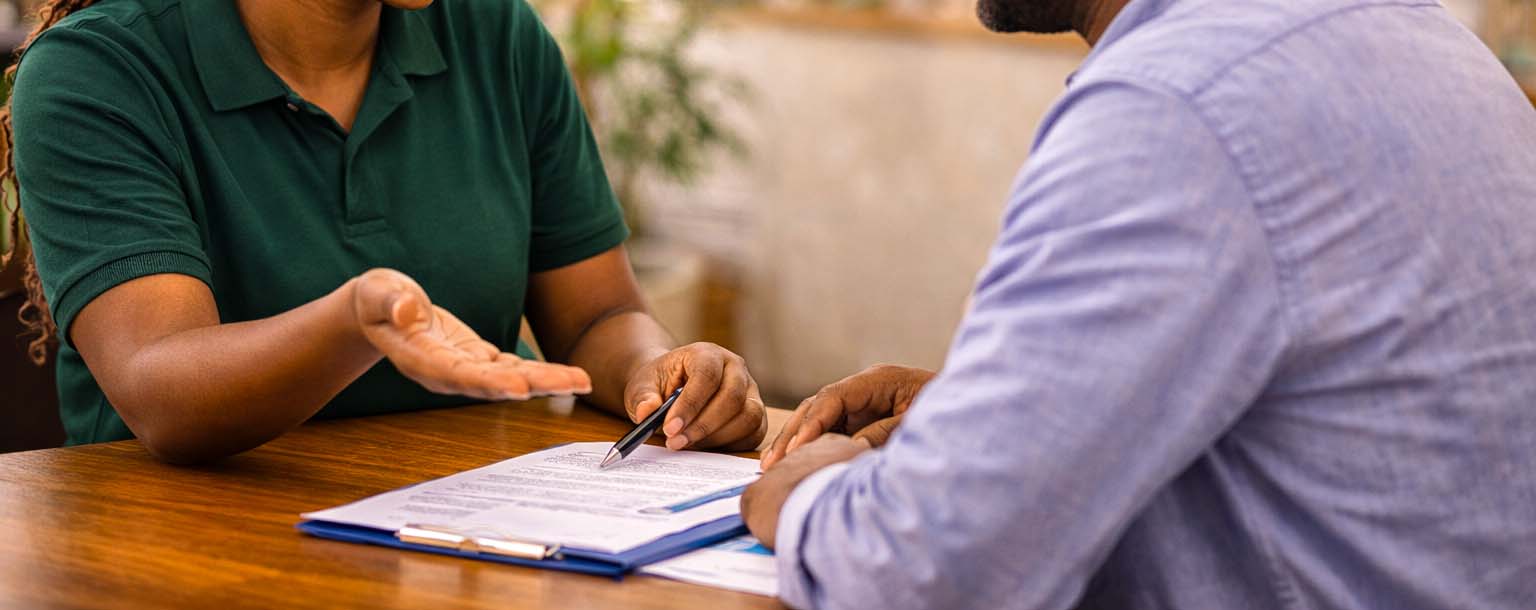 Person signing a loan agreement contract for Capital Loan approval at Kenyatta Matibabu SACCO in Nairobi
